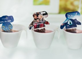 Drei Teefiguren in Tassen mit duftendem Tee.